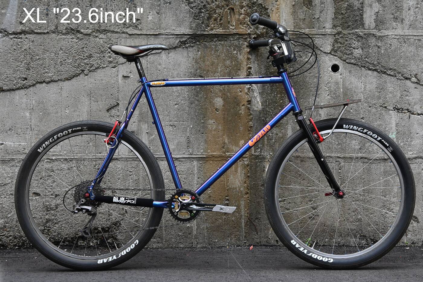 Magic Components' own drive-side photo of an XL Wizard in the purple flip finish, built up with a front rack, chainstay protector and 26 inch tyres
